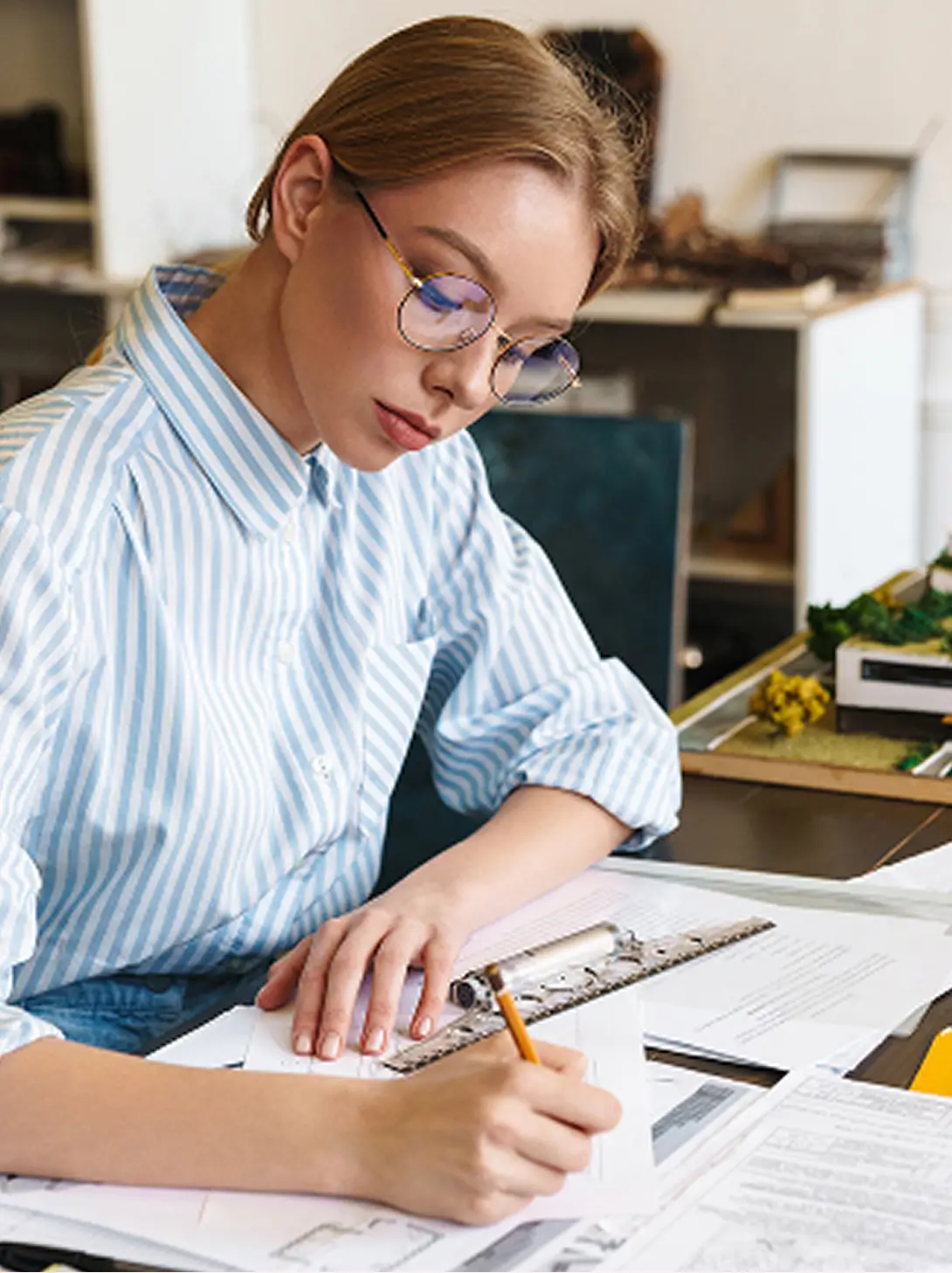 Young Woman Works On A Construction Drawing In The Office